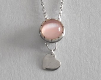 Handmade sterling silver necklace with a cateye gemstone and a heart pendant.