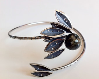 Handmade sterling silver bracelet with leaf motifs and a hawk-eye stone.