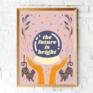Puede incluir: Un póster ilustrado rosa y blanco con una bola de cristal que dice "the future is bright". Dos manos naranjas sostienen la bola de cristal, y dos gatos estilizados negros y azules están a cada lado de las manos.