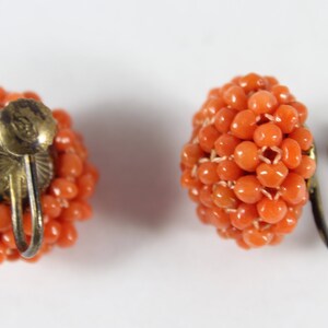 May include: A pair of orange coral bead earrings with gold-tone clip-on backs.