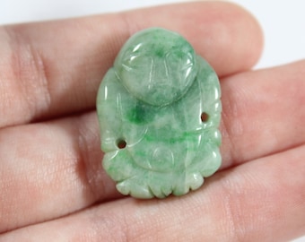 May include: A green jade carving of a smiling Buddha, a traditional Chinese symbol of good luck and prosperity.