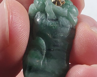 May include: A green jade pendant carved in the shape of a dragon with a gold bail. The pendant is about 2 inches long and 1 inch wide.
