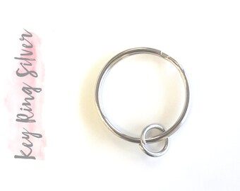 May include: A silver key ring with a single large ring and a smaller connecting ring.