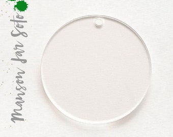 May include: A clear round acrylic ornament with a hole at the top for hanging. The ornament is blank and ready to be decorated.
