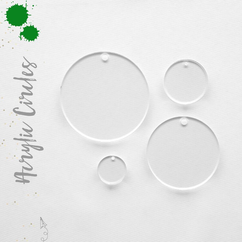 May include: Four clear acrylic circles of varying sizes with a small hole at the top of each circle. The circles are arranged on a white surface.