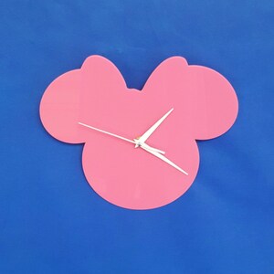 May include: Pink wall clock shaped like a cartoon mouse head with white hands.