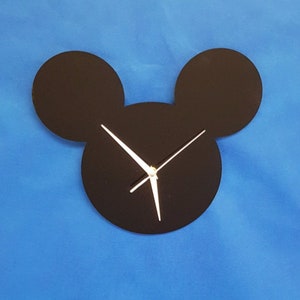May include: Black Mickey Mouse shaped wall clock with white hands.