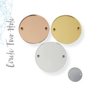 May include: Four round metal circles with two holes each. The circles are in rose gold, gold, silver, and a darker silver color.