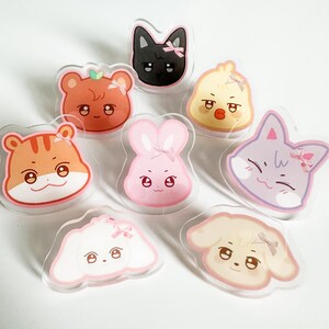 Puede incluir: Conjunto de ocho amuletos de acrílico de personajes de dibujos animados de animales coloridos con lazos rosas. Los personajes incluyen un gato, un pollito, un conejito, un tigre, un perro, un oso y dos perros más.