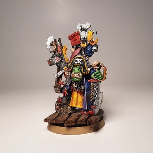 May include: A painted miniature of an Ork warboss, a large green humanoid with a blue and yellow robe, holding a large axe and standing on a wooden base.