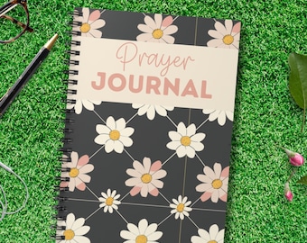 Può includere: Un diario a spirale nero e bianco con un motivo floreale e il testo "Prayer Journal" sulla copertina.
