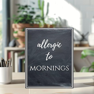 Charming "Allergic to Mornings" printable sign with a rustic chalkboard design. Features elegant white script and serif text on a textured black background with a double-line border. Perfect for home, classroom, or office decor!