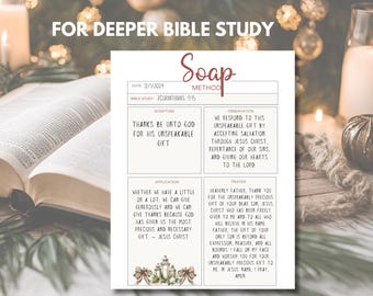 Può includere: Un foglio di lavoro bianco per lo studio biblico del metodo SOAP con testo, tra cui "Grazie a Dio per il suo dono ineffabile". Il foglio di lavoro è su un tavolo con un libro aperto e candele.