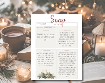 Può includere: Una scheda stampata per lo studio della Bibbia con il "METODO SOAP", con testo sulla gratitudine e la fede. La scheda è circondata da candele, una tazza di caffè e un libro, creando un'atmosfera calda e stimolante.