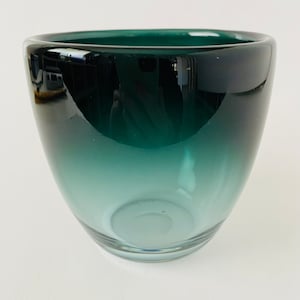 May include: A teal glass bowl with a gradient effect, fading from dark to light.