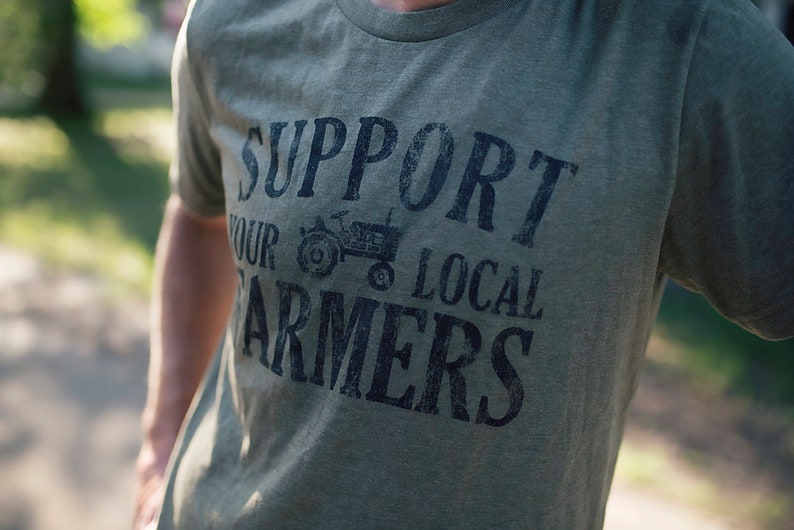May include: A green t-shirt with a distressed black graphic that says "Support Your Local Farmers" with a small tractor image.