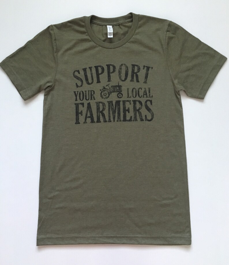May include: A green t-shirt with the text "Support Your Local Farmers" in black lettering. A black silhouette of a tractor is included in the text.