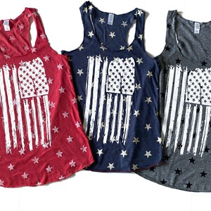 May include: Three tank tops with a distressed American flag design. The tank tops are red, navy blue, and gray with white stars.