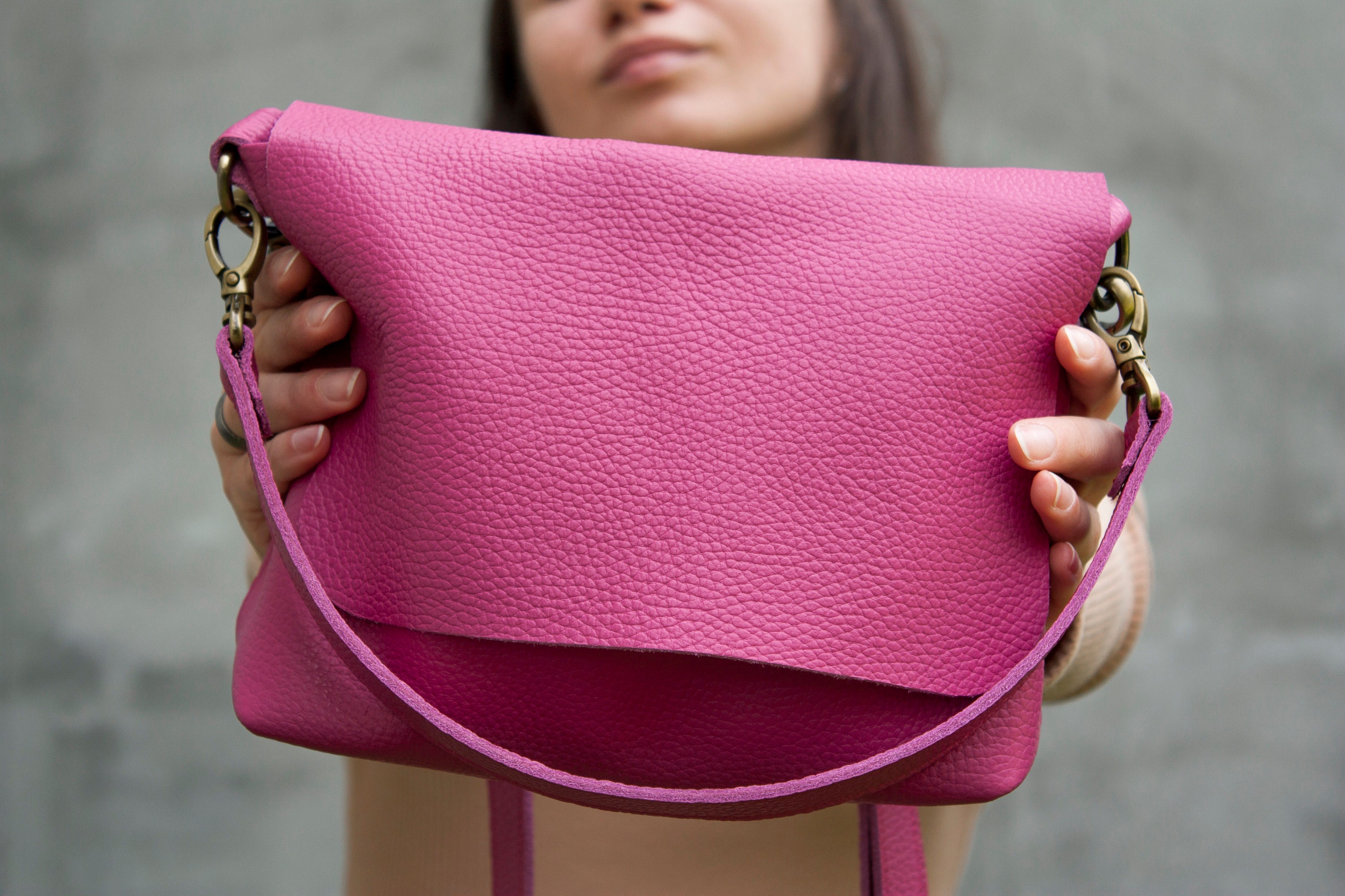 Woman holding brown and pink floral leather crossbody bag photo