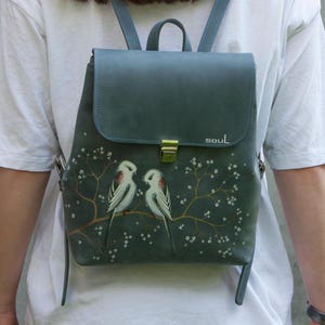 Mochila pequeña de cuero azul con pintura de herrerillos blancos de cola larga, bolso de cuero mate, mochila hecha a mano con pájaros y flores