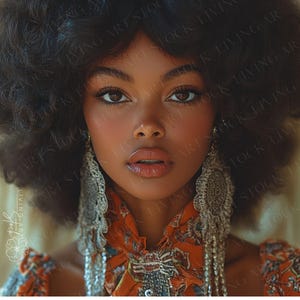 Puede incluir: Retrato de una persona con piel oscura, ojos marrones y labios carnosos. Lleva pendientes grandes y plateados con diseños intrincados y una blusa estampada en naranja y azul. Su cabello es un afro grande y oscuro.