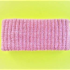 May include: A pink knitted headband with a ribbed texture.