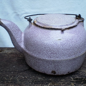 May include: A vintage purple cast iron teapot with a lid and a wire handle.