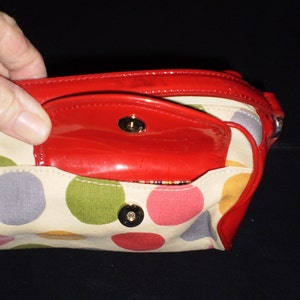 May include: A red and white polka dot handbag with a red patent leather flap and a gold metal closure.