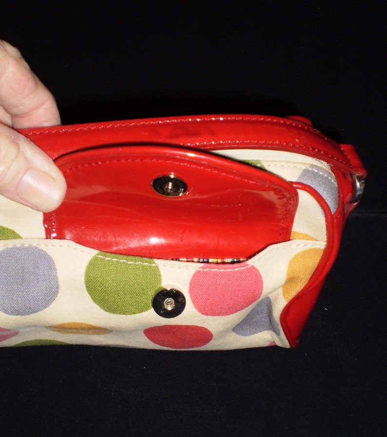 May include: A red and white polka dot handbag with a red patent leather flap and a gold metal closure.