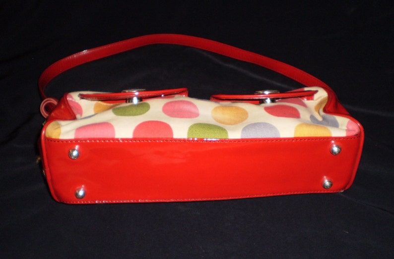 May include: A red patent leather handbag with a cream canvas body featuring a multi-coloured polka dot pattern.
