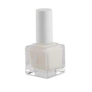 May include: A clear glass bottle of white nail polish with a white cap. The bottle is square shaped and has a textured surface.