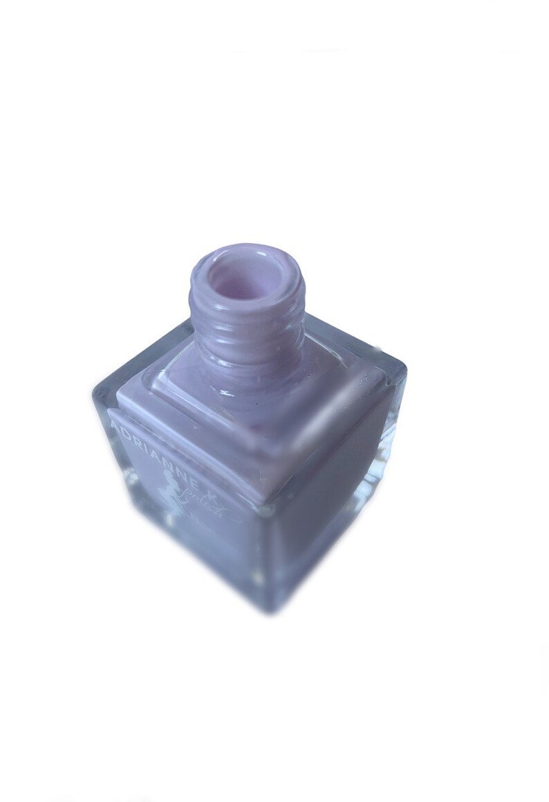 Peut inclure: Un flacon carr&eacute; de vernis &agrave; ongles violet clair avec un bouchon transparent. Le flacon est &eacute;tiquet&eacute; "Adrianne"