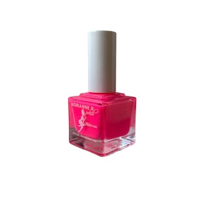 Peut inclure: Un flacon de vernis à ongles rose avec une base en verre transparent et un bouchon blanc. Le flacon porte une étiquette avec le texte "Adrianne K polish" et une petite illustration d'une ballerine. L'étiquette indique également "Non-toxique".