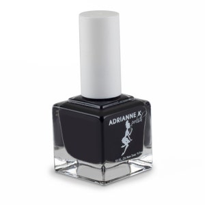 May include: A clear glass bottle of black nail polish with a white cap. The bottle has a label that says "Adrianne K polish" and a small illustration of a fairy. The label also says "5.1 FL. Oz. Non-Toxic 5 Free".