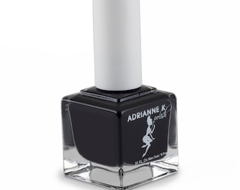 May include: A clear glass bottle of black nail polish with a white cap. The bottle has a label that says "Adrianne K polish" and a small illustration of a fairy. The label also says "5.1 FL. Oz. Non-Toxic 5 Free".