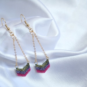 May include: A pair of long, gold dangle earrings with a chevron-shaped beaded charm in shades of pink, purple, and green.