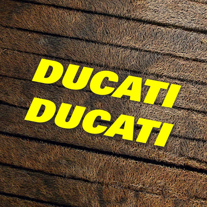 May include: The word "DUCATI" is written twice in yellow letters on a brown, textured background.