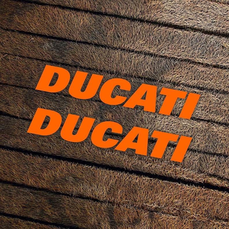 May include: The word "DUCATI" is written twice in orange letters on a brown, textured background.