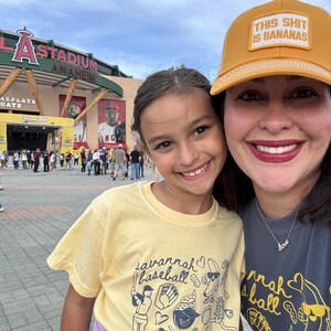Puede incluir: Un selfie de dos personas sonriendo frente a un estadio. Una persona lleva una gorra de b&eacute;isbol amarilla con el texto "THIS SHIT IS BANANAS". La otra persona lleva una camiseta amarilla con el texto "savannah baseball."