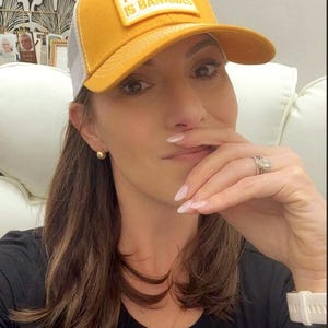 Puede incluir: Gorra de b&eacute;isbol de color amarillo mostaza con la parte trasera de malla blanca. La gorra presenta el texto "THIS SHIT IS BANANAS" en un parche rectangular. La persona de la imagen lleva una camiseta negra y un collar dorado.
