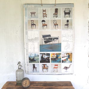 May include: Vintage poster featuring various chair designs, including a round stool, a high-backed chair, and a modern cantilever chair. The poster is displayed on a distressed white wall, with a glass bottle and a clock on a wooden surface.