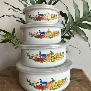 May include: Set of four white enamel nesting bowls with lids. Each bowl features a colorful peacock design with yellow, blue, green, and red accents.
