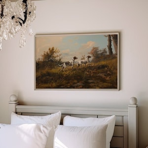 Può includere: Un dipinto incorniciato che rappresenta una scena di caccia con tre cani in un campo. I cani sono bianchi con macchie marroni e corrono attraverso l'erba alta. Il dipinto è ambientato sullo sfondo di alberi e un cielo nuvoloso.