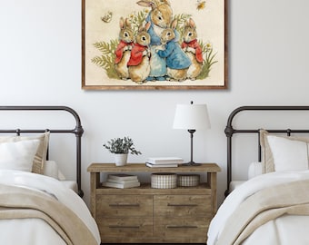 Op de afbeelding: Een rechthoekige ingelijste wandkunstprint met een aquarelillustratie van vijf konijnen in rode en blauwe jasjes in groen gebladerte. De tekst luidt: Once upon a time there were four little Rabbits, and their names were Flopsy, Mopsy, Cotton-tail and Peter.