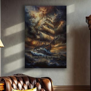 Pode incluir: Uma impressão de arte de parede retangular apresentando um grande veleiro navegando em ondas oceânicas escuras e turbulentas sob um céu dramático e tempestuoso. O texto MIGHTIER THAN THE WAVES OF THE SEA IS HIS LOVE FOR YOU está em branco.