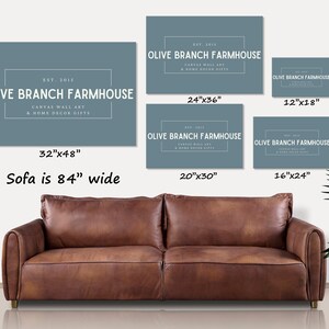 May include: A set of six blue canvas wall art prints with the text "Olive Branch Farmhouse" and different size options. The prints are shown above a brown leather sofa.