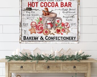 May include: A rectangular wall sign with a distressed white background featuring the text Candy Cane Lane Hot Cocoa Bar and Bakery & Confectionery. The graphic includes a mug of cocoa with cinnamon sticks, a reindeer, and assorted holiday cookies.