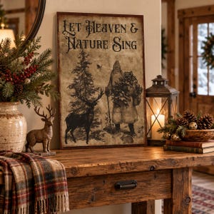 May include: A rectangular wall sign with a vintage-style, distressed beige background featuring the text 'Let Heaven & Nature Sing' in black. The illustration depicts a standing figure in a long coat, a tall pine tree, and a deer in silhouette.