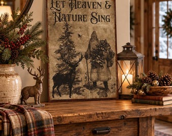 May include: A rectangular wall sign with a vintage-style, distressed beige background featuring the text 'Let Heaven & Nature Sing' in black. The illustration depicts a standing figure in a long coat, a tall pine tree, and a deer in silhouette.