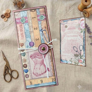 May include: A tall rectangular card featuring a vintage sewing theme with a corset illustration, a measuring tape graphic, and a button closure. Beside it is a smaller rectangular card with a pink building illustration and the text "Smallpage & Son Tailors".